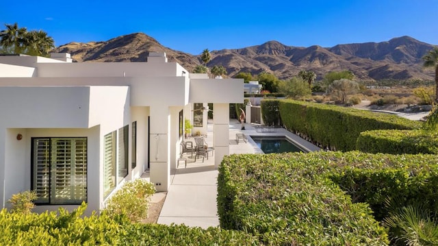 rear view of property with a mountain view and a patio area