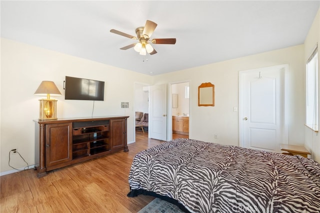 bedroom with light wood-style floors and connected bathroom