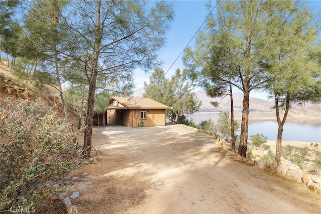 view of property exterior featuring a water view and driveway