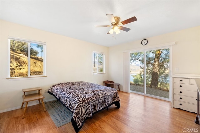 bedroom featuring light wood finished floors, access to outside, baseboards, and a ceiling fan