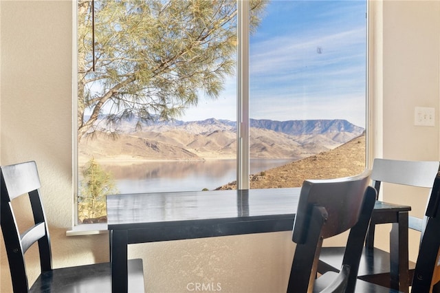 interior space featuring a textured wall and a water and mountain view