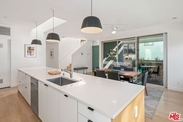 kitchen featuring pendant lighting, sink, white cabinetry, and a kitchen island