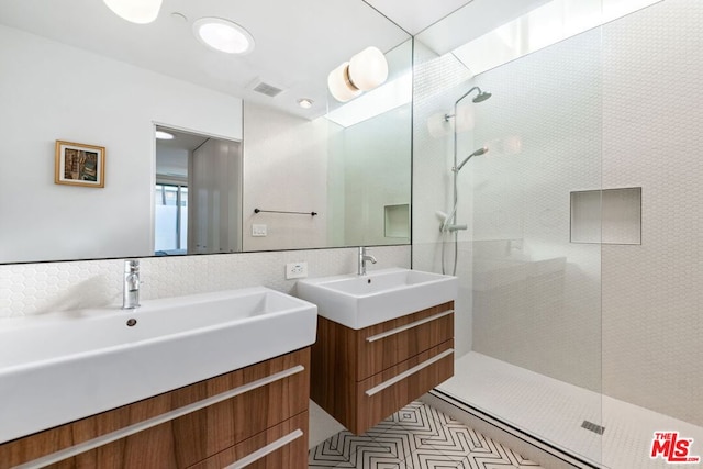 bathroom with tiled shower and vanity