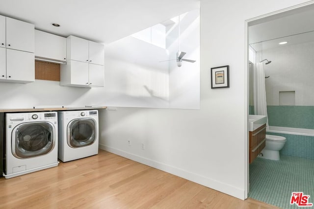 laundry room with ceiling fan, washer and clothes dryer, and light hardwood / wood-style flooring