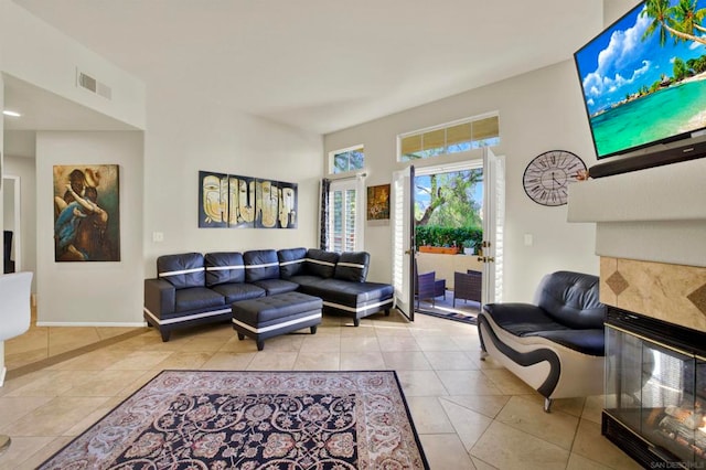 living room with light tile patterned floors and a tile fireplace