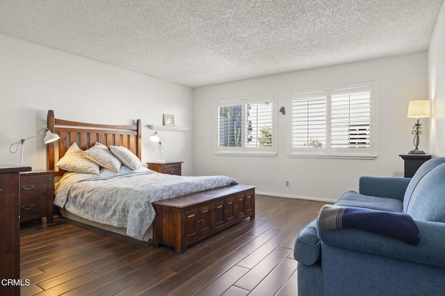 bedroom with dark hardwood / wood-style floors and a textured ceiling