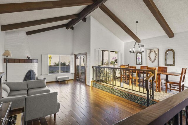 living room featuring high vaulted ceiling, a notable chandelier, and beamed ceiling