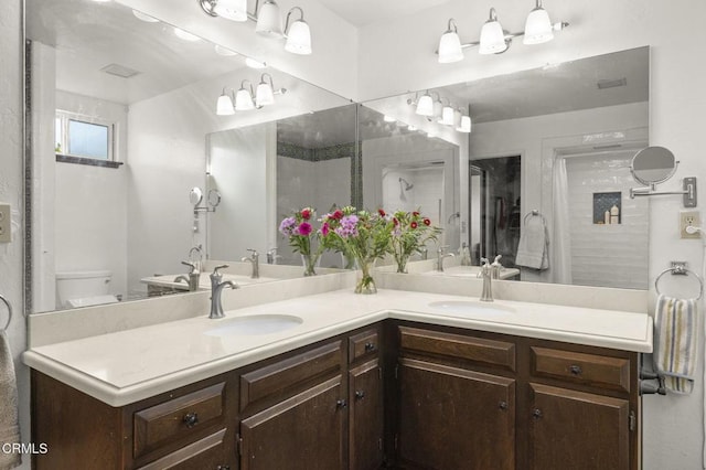 bathroom featuring toilet, a shower with shower door, and vanity