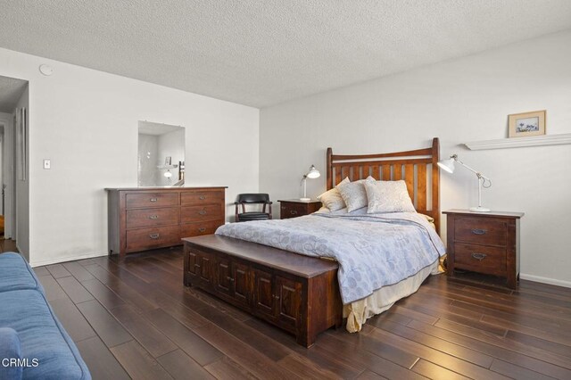 bedroom featuring dark hardwood / wood-style flooring and a textured ceiling