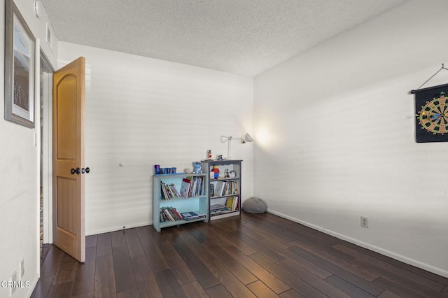 miscellaneous room with a textured ceiling and dark wood-type flooring