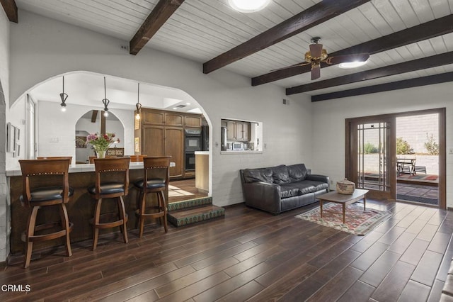 living room featuring ceiling fan, wood ceiling, and beamed ceiling