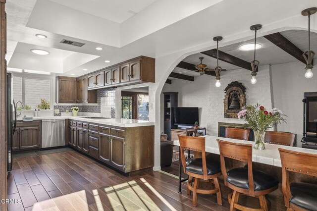 kitchen with ceiling fan, tasteful backsplash, decorative light fixtures, dark brown cabinets, and stainless steel dishwasher