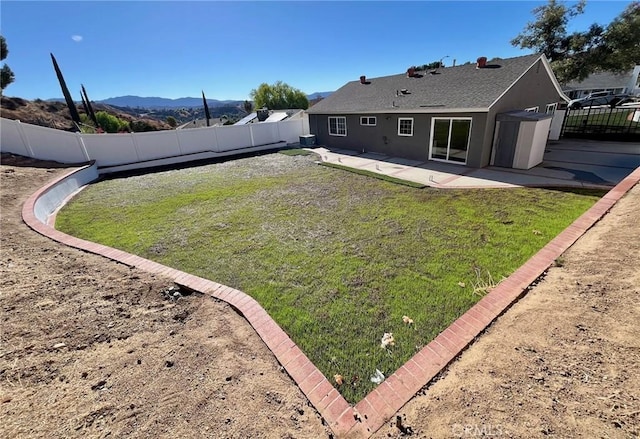 back of property featuring a patio area, a lawn, and a mountain view