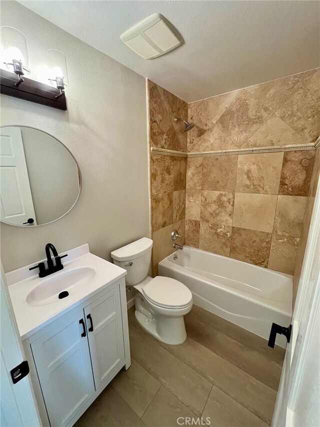 full bathroom with toilet, tiled shower / bath combo, and vanity