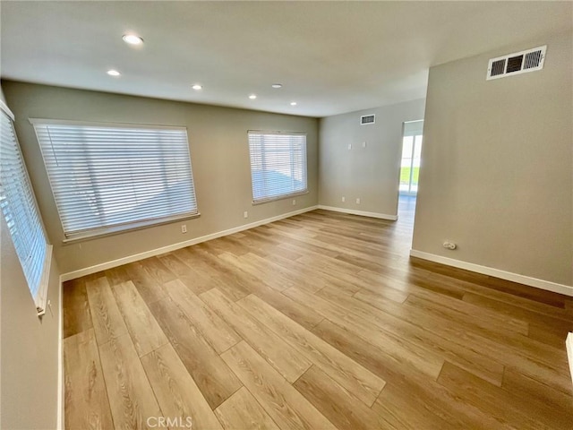 spare room with a wealth of natural light and light hardwood / wood-style flooring