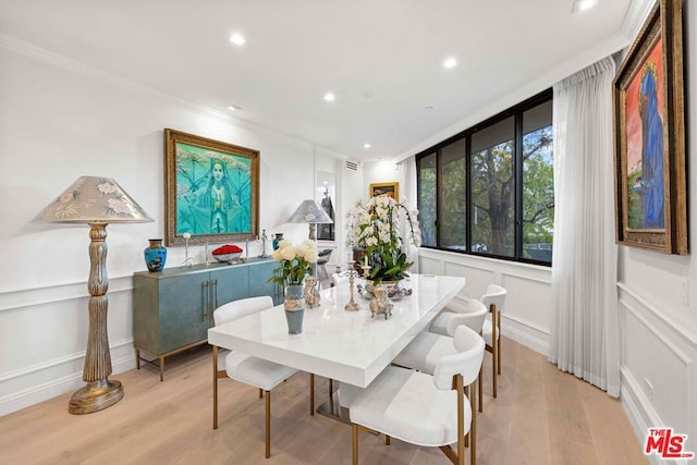 dining space featuring light wood-type flooring and ornamental molding