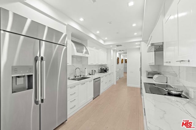 kitchen featuring sink, light stone counters, stainless steel appliances, and white cabinetry