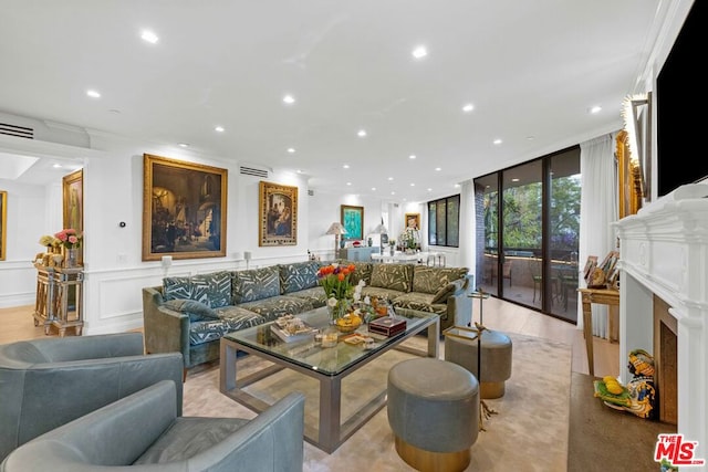 living room with ornamental molding, light hardwood / wood-style floors, and floor to ceiling windows