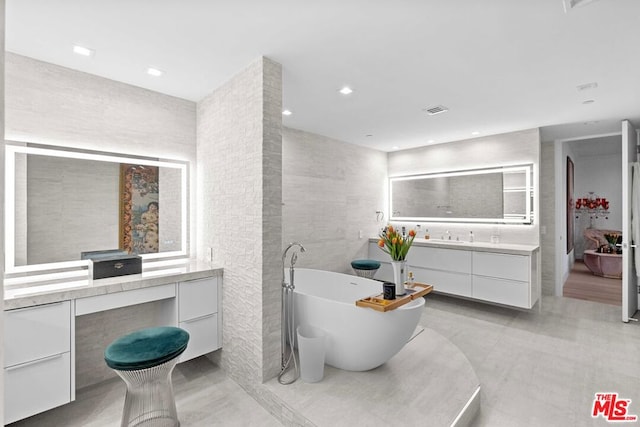 bathroom featuring tile walls, a washtub, and vanity