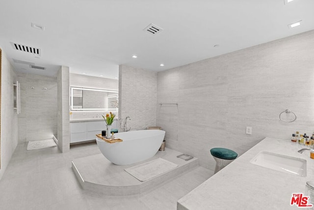 bathroom featuring tile walls, vanity, and separate shower and tub