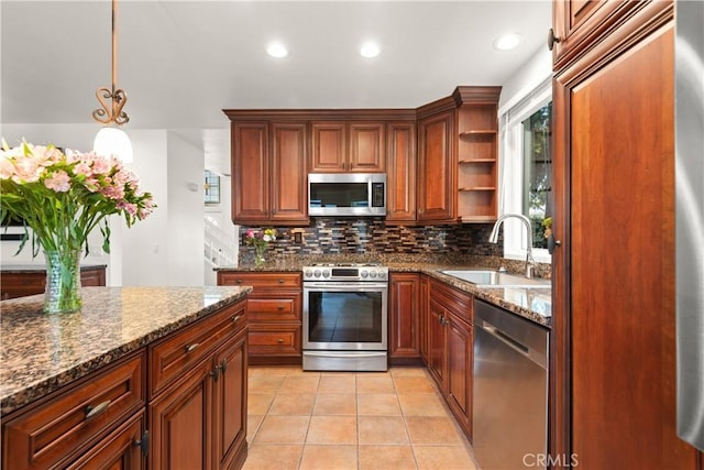 kitchen with tasteful backsplash, dark stone counters, sink, pendant lighting, and stainless steel appliances