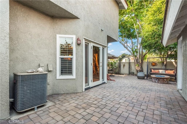 view of patio with an outdoor fire pit and central AC