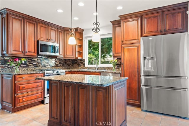 kitchen with appliances with stainless steel finishes, a center island, dark stone counters, sink, and hanging light fixtures