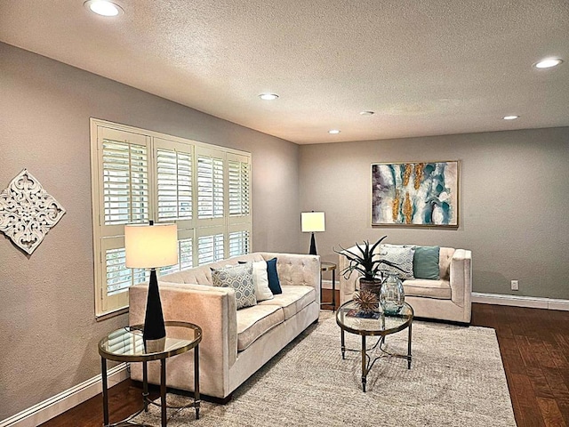 living room featuring dark wood-type flooring and a textured ceiling