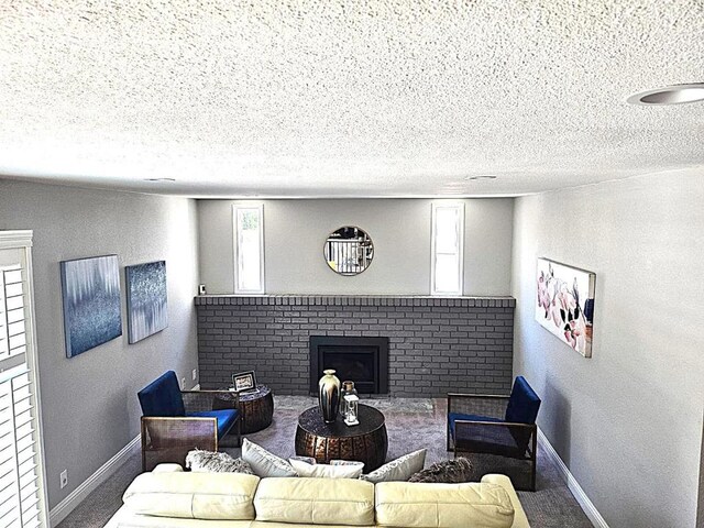 living room featuring plenty of natural light, a textured ceiling, and a fireplace