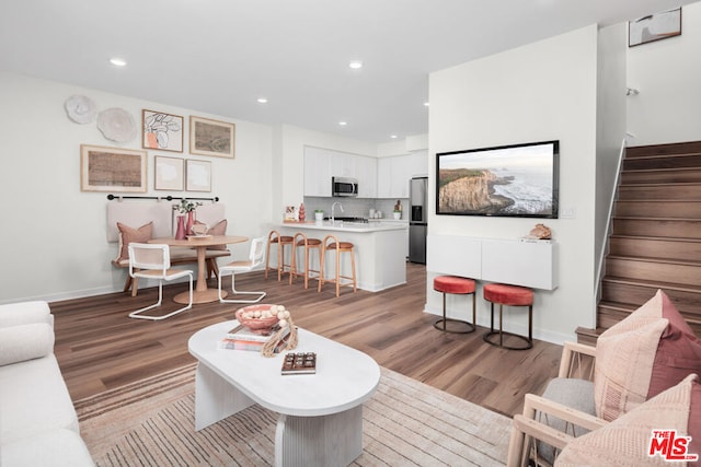 living room featuring sink and light hardwood / wood-style flooring