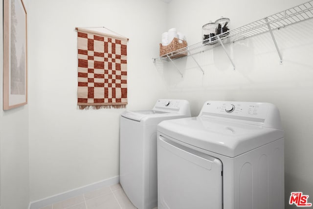 laundry area with light tile patterned floors and washing machine and dryer