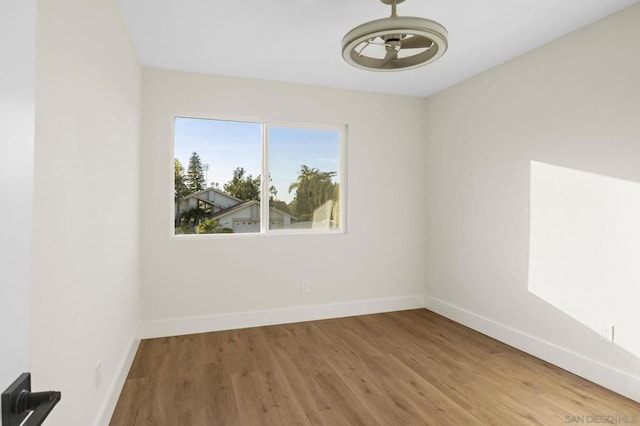 empty room with ceiling fan and hardwood / wood-style flooring