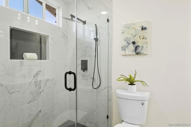 bathroom with toilet and an enclosed shower