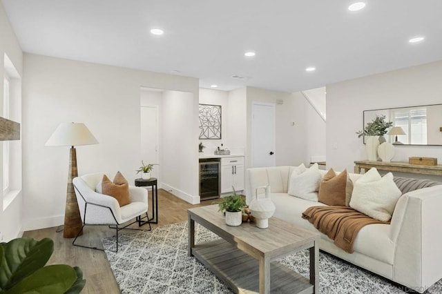 living room featuring light hardwood / wood-style floors, bar, and wine cooler