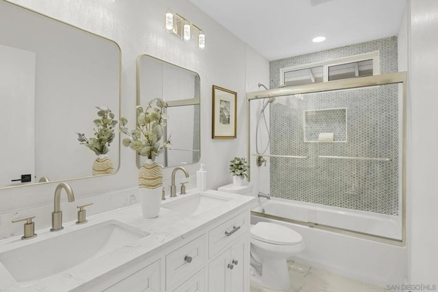 full bathroom with toilet, bath / shower combo with glass door, and vanity