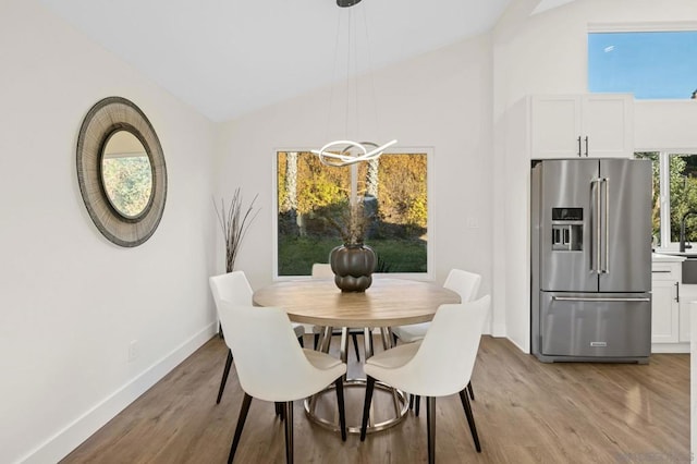 dining area with vaulted ceiling and light hardwood / wood-style floors