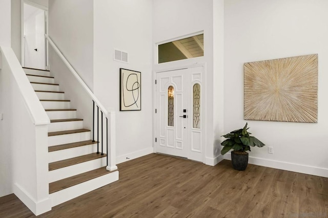 foyer with high vaulted ceiling and dark hardwood / wood-style floors