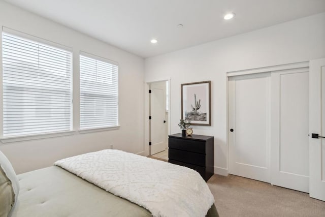 bedroom with light carpet and a closet