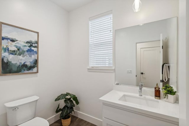 bathroom with vanity, toilet, hardwood / wood-style floors, and plenty of natural light