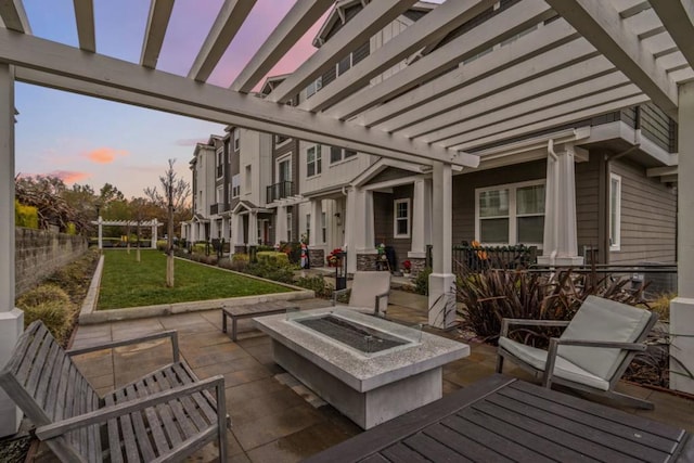 patio terrace at dusk with a pergola, a yard, and a fire pit