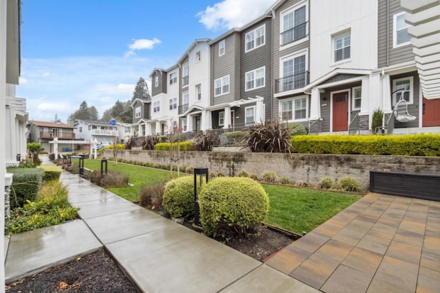 view of property's community featuring a pergola and a lawn