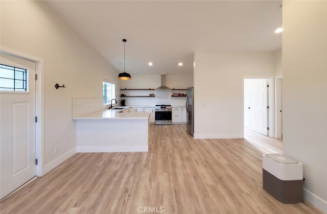 kitchen with kitchen peninsula, appliances with stainless steel finishes, backsplash, pendant lighting, and sink