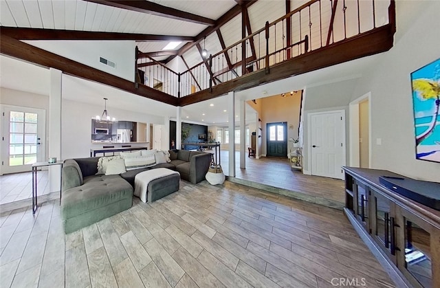 living room featuring high vaulted ceiling, beam ceiling, and a notable chandelier