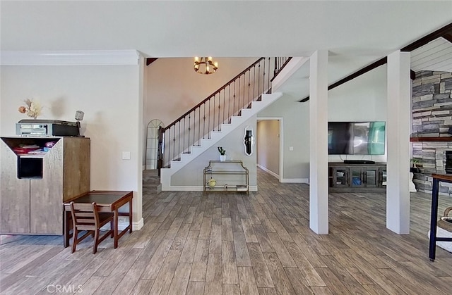 foyer with a chandelier, ornamental molding, and hardwood / wood-style flooring