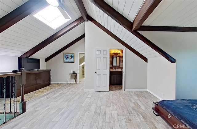 additional living space featuring sink, light hardwood / wood-style flooring, and vaulted ceiling with beams