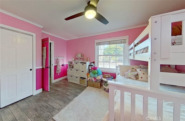 bedroom with ceiling fan, crown molding, and hardwood / wood-style flooring