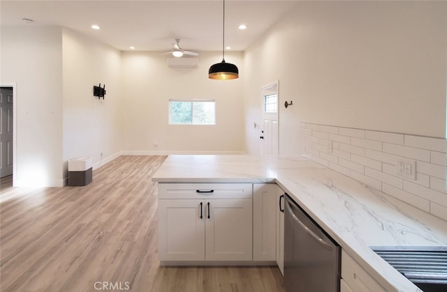 kitchen featuring kitchen peninsula, ceiling fan, white cabinets, hanging light fixtures, and light stone counters