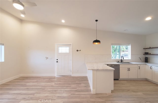 kitchen with white cabinets, dishwasher, decorative light fixtures, vaulted ceiling, and light stone counters