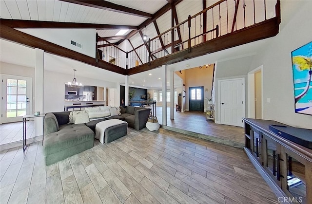 living room with high vaulted ceiling, beamed ceiling, and a notable chandelier