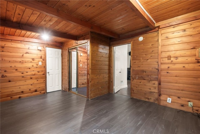 spare room with beamed ceiling, wooden walls, wooden ceiling, and dark wood-style floors
